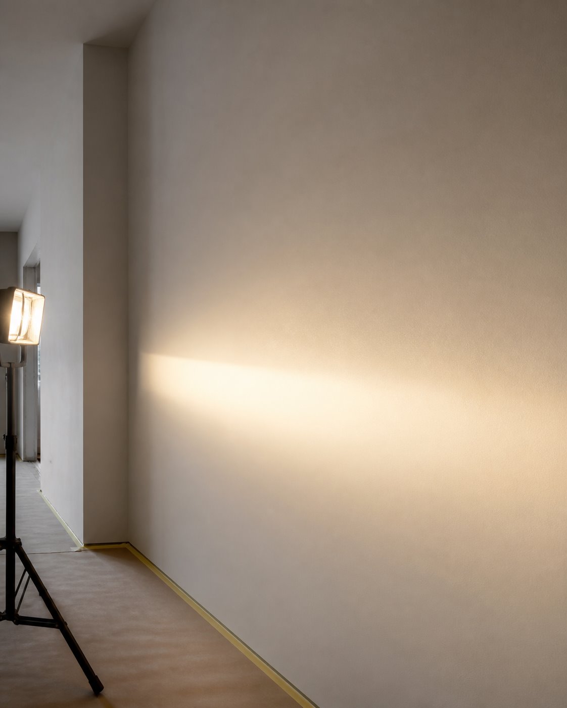 Glatte gespachtelte Wand im Streiflicht einer Arbeitsleuchte